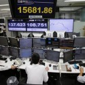 Employees at a foreign exchange brokerage sit at a computer terminal under electric boards flashing the current figures of Japanese yen against dollar and stock market in Tokyo, Thursday, Oct. 2, 2014. Asian stocks fell Thursday amid worries about the strength of U.S. and European recoveries and the first American case of Ebola. Japan's Nikkei 225 index lost 1.7 percent to 15,815.45 points. (AP Photo/Shuji Kajiyama)