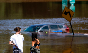 People look at a car flooded flooded as a result of the remnants of Hurricane Ida in a local street in Somerville, N.J., Thursday, Sept. 2, 2021.