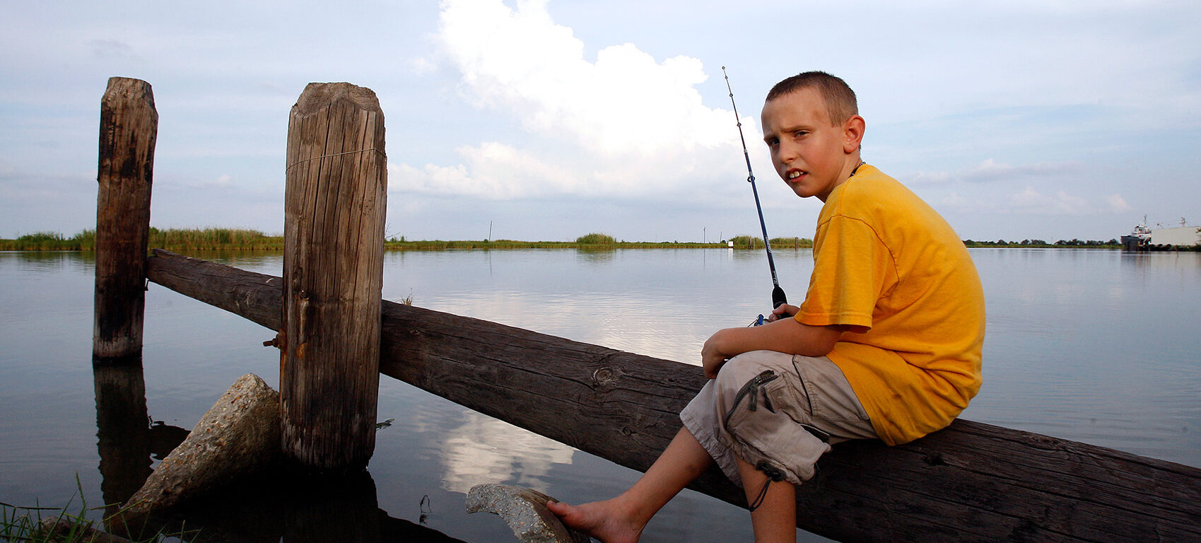 In this Aug. 5, 2010 picture, Zack Wilkerson, 9, sits with his fishing pole on Bayou Lafourche in Galliano, La. Summers used to be filled with trips to the beach less than an hour away at Grand Isle, but the oil has kept the Wilkersons--and many others--from the sand and surf. The Children's Health Fund survey found nearly 85 percent of parents along the Gulf have stayed away from the water because of the spill. (AP Photo/Patrick Semansky)