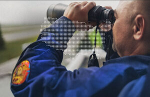 A man looking with binoculars